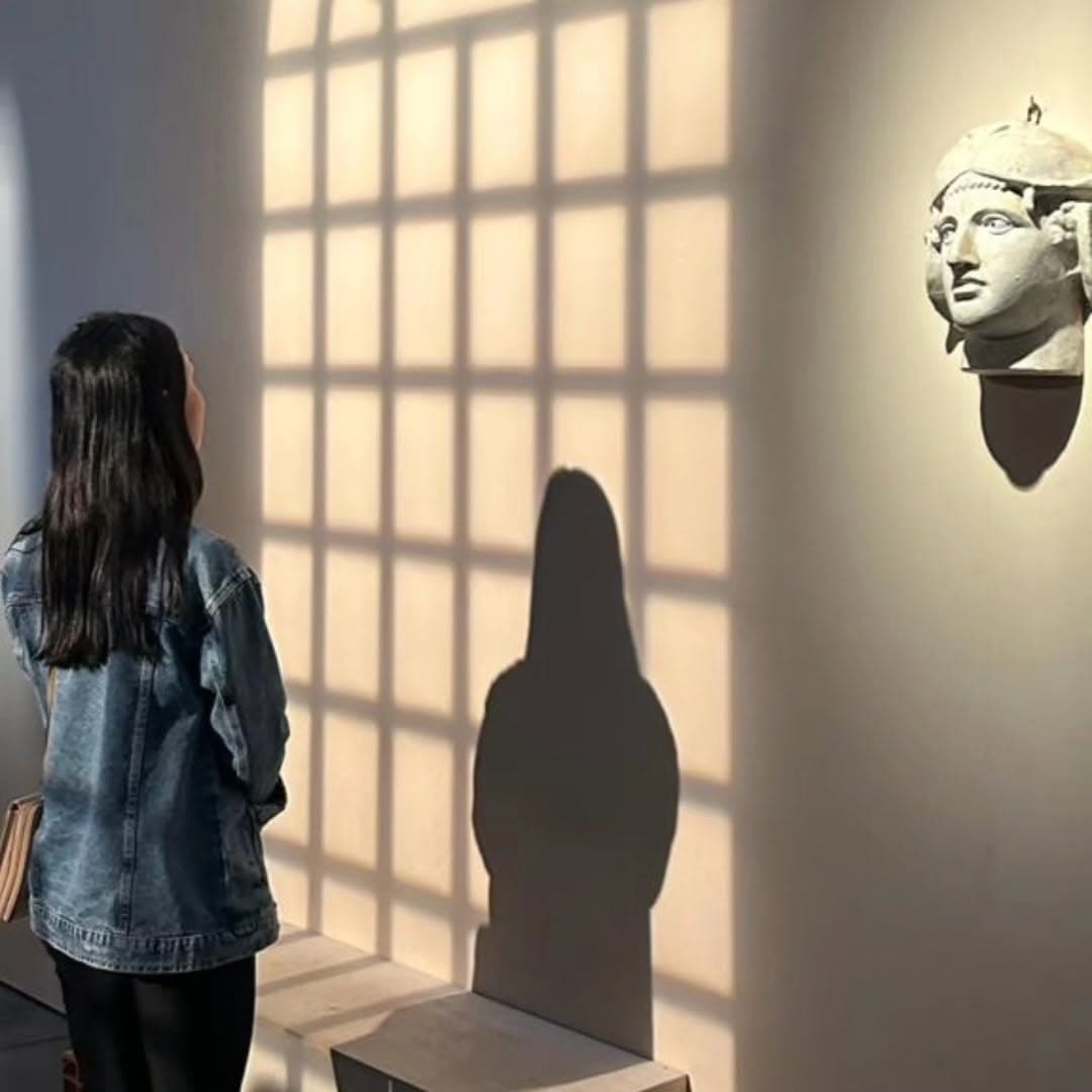 Gatana de costas na exposição sobre Nise da Silveira, diante de uma escultura
